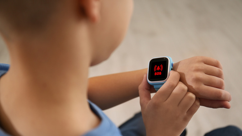 Little boy using the SOS function on a smartwatch