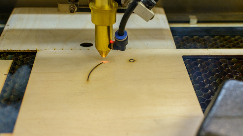 A laser cutter cutting through a board