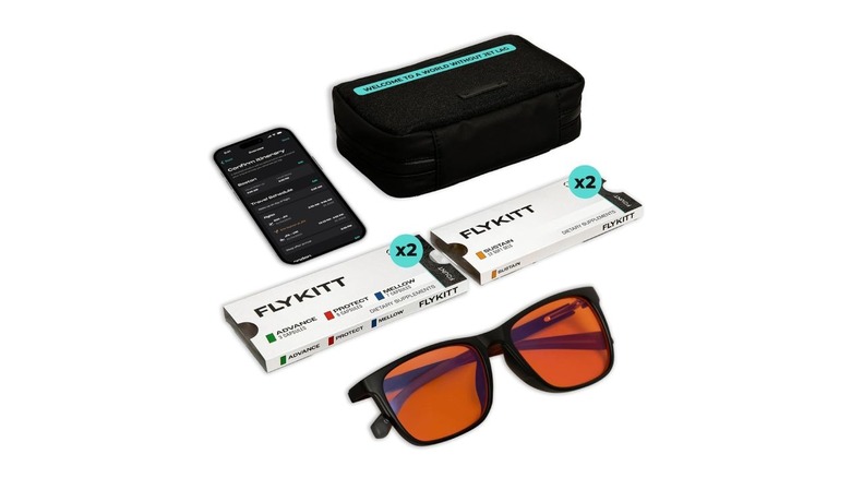The Flykitt kit, which includes sunglasses, four boxes of supplements, and a phone with an app open.