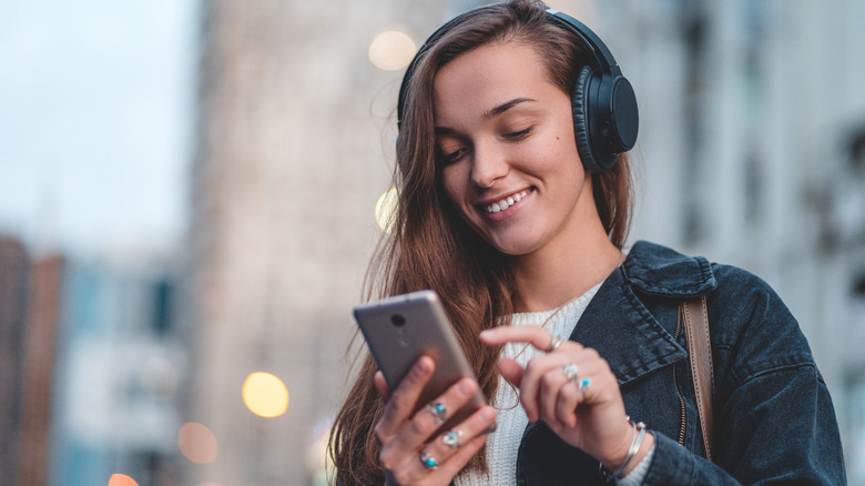 A wireless pair of headphones connected to a smartphone