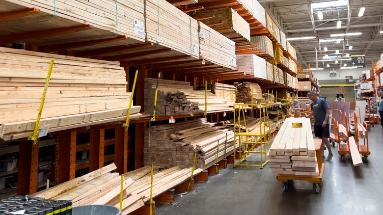 Lumber section at Home Depot with man loading cart