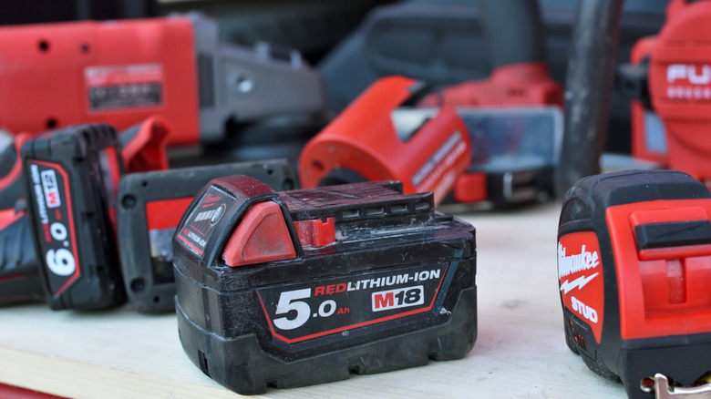 A Milwaukee M18 battery and other accessories on a table.