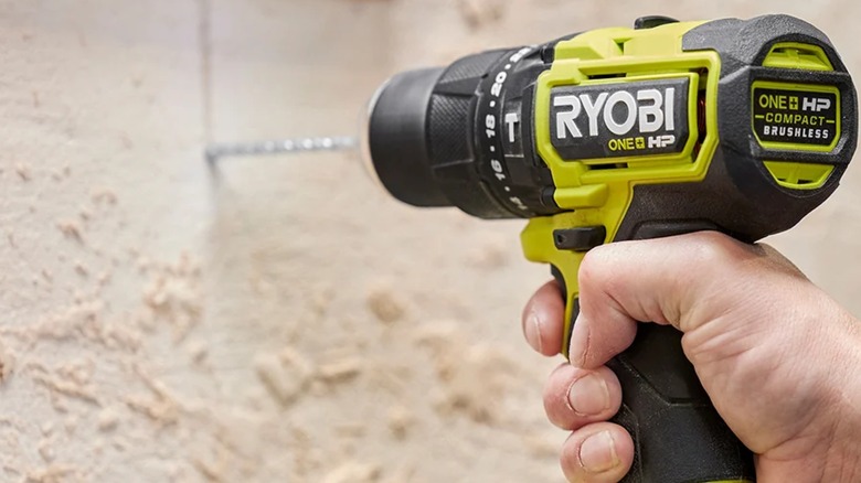 Drilling into a wall using a Ryobi hammer drill.