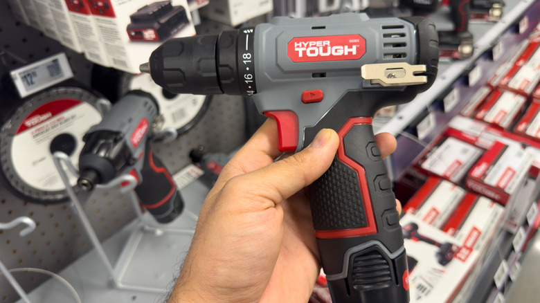 A person looking at a power drill in a hardware store.