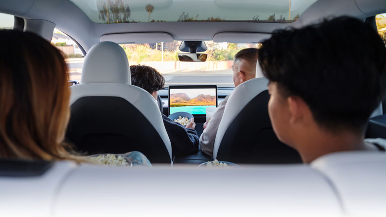 four people sitting in a Tesla Model Y
