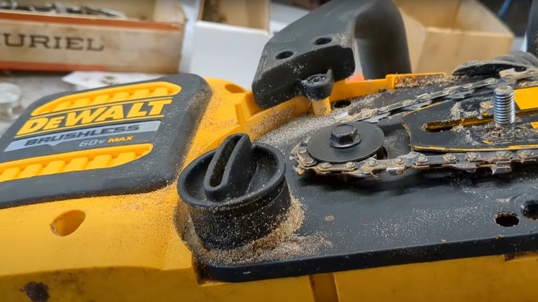 Partially disassembled DeWalt chainsaw showing chain tensioner