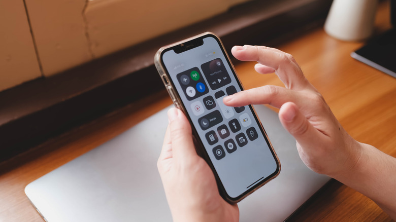 A person accessing the iPhone's Control Center