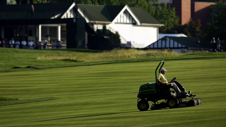 Man cutting lawn with John Deere riding Mower