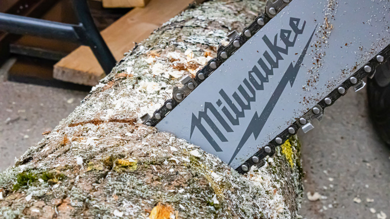 A close up of a chainsaw in motion with Milwaukee brand name
