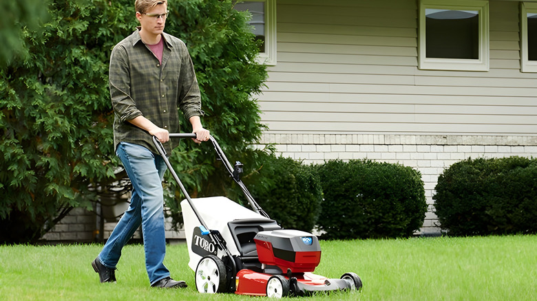 Man using a walk-behind Toro mower