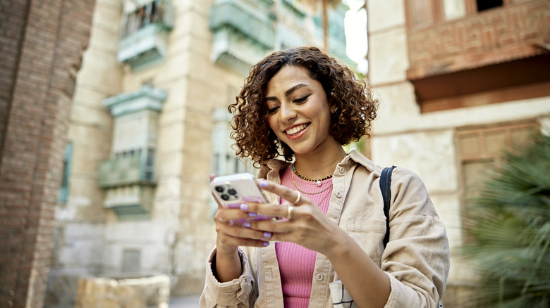 Person smiling while holding iPhone 