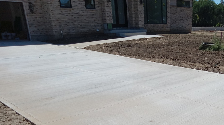 A freshly installed concrete driveway outside of a newly-constructed residential home