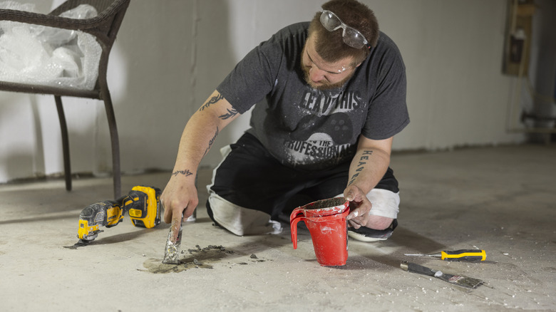 A worker sealing a cracked concrete floor