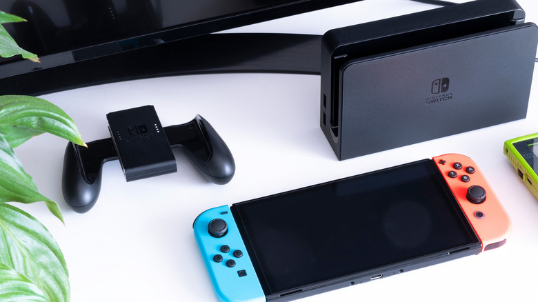 Nintendo Switch laying next to Swtich dock and controller
