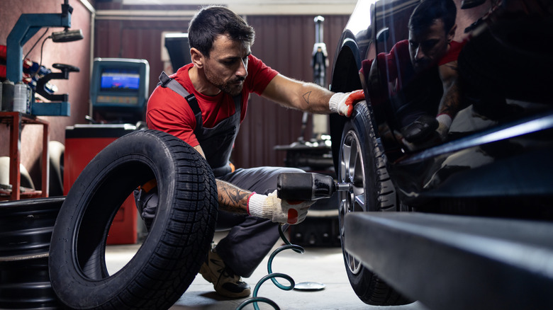Mechanic changing tire on a car