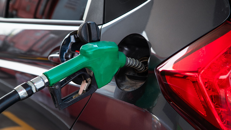 Closeup of fuel nozzle refueling a car
