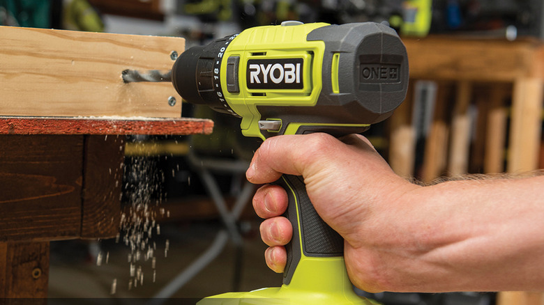person using ryobi power drill