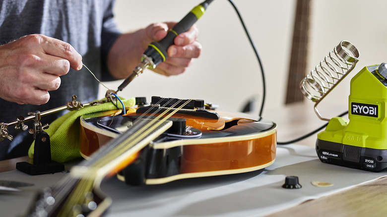 person using ryobi soldering iron