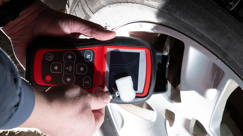 A mechanic programming a TPMS sensor with a scan tool