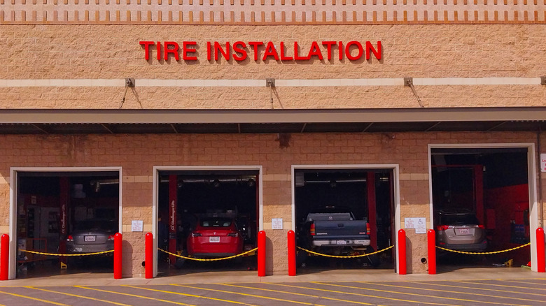 A Costco tire shop pictured from the outside with four cars parked in