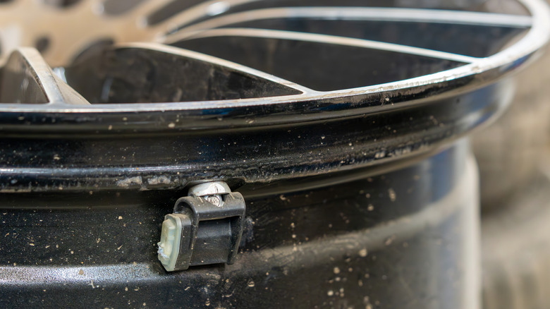 A TPMS sensor mounted on the outside of a car rim.