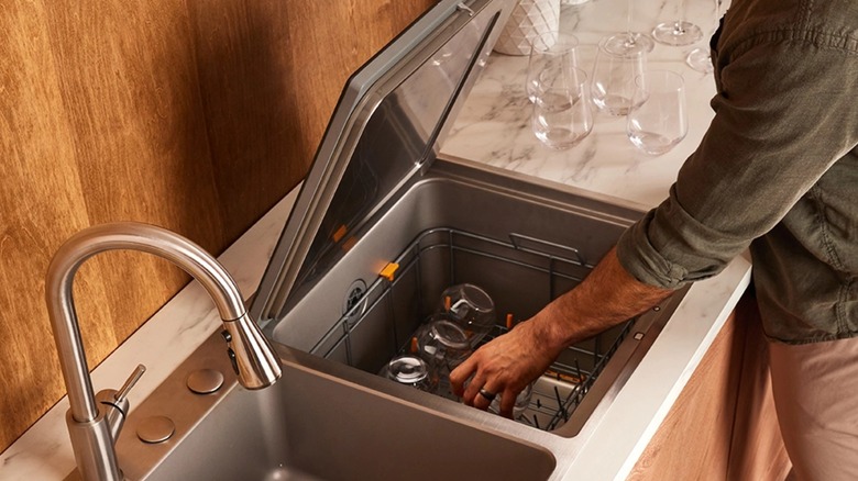 man loading dishwasher from top