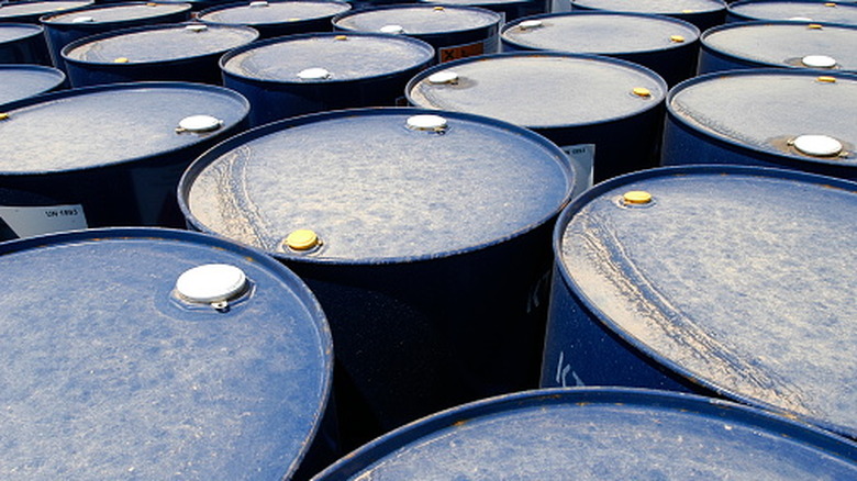 Several metal oil drums packed together.