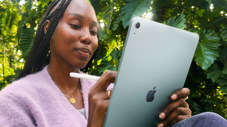 A woman using a gray iPad Air 11-inch with an Apple Pencil.