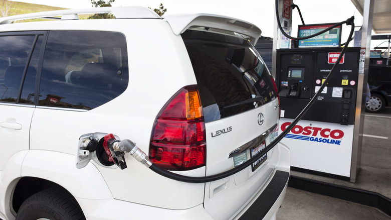 A white Lexus SUV getting gas at a Costco gas station pump