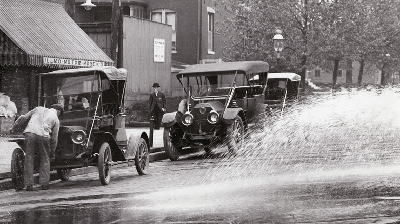 man cranking a vintage car 