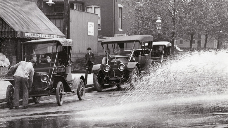 man cranking a vintage car