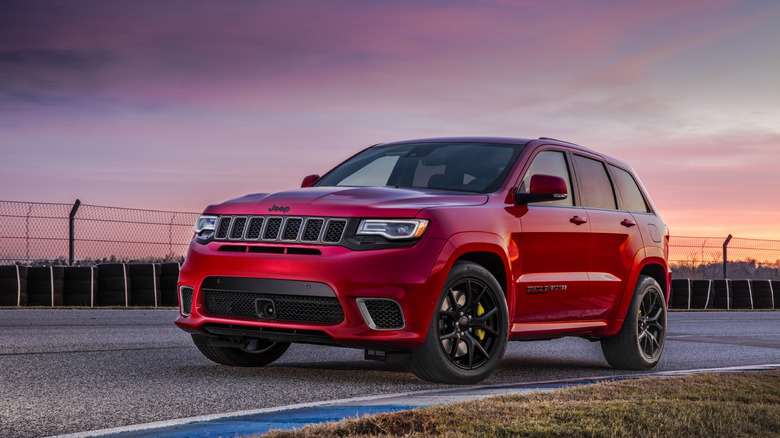 Jeep Grand Cherokee Trackhawk parked on racetrack during sunset, front-left three-quarter view