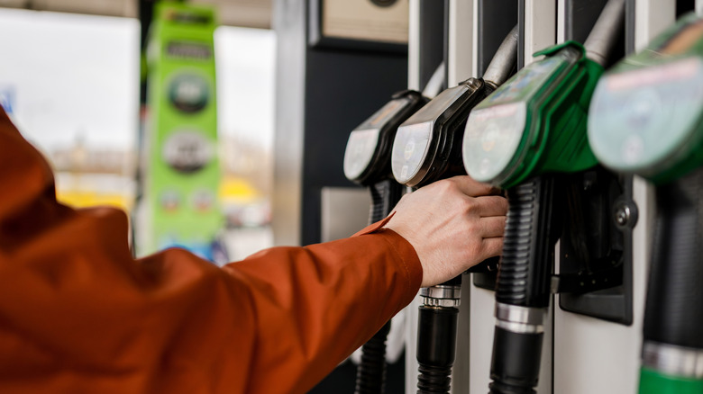 A person grabbing a gas pump