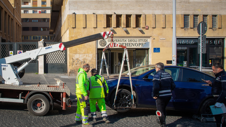 Towing crew attaching a car to the towing truck