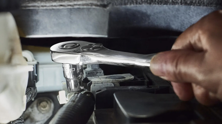 Person using a Craftsman socket wrench to fix a car