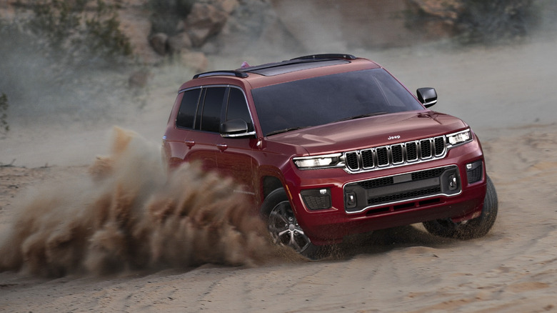 Front view of red Jeep Grand Cherokee L off-roading in the sand.
