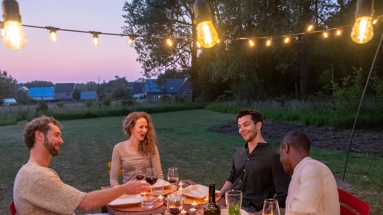 people in backyard with string lights