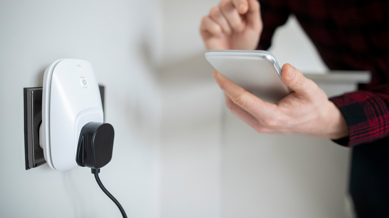 person using phone with smart plug