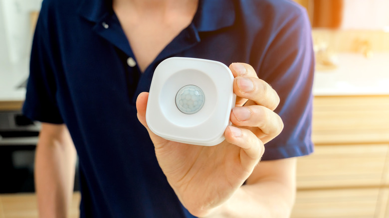 man holding motion detector