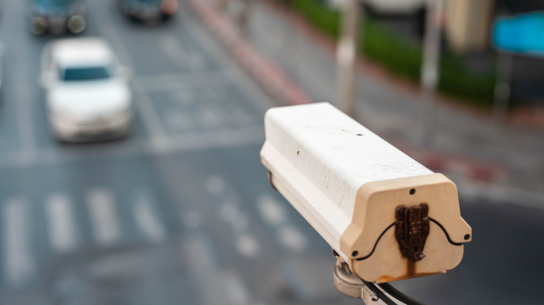 An automatic license plate reader camera from behind overlooking a busy intersection.