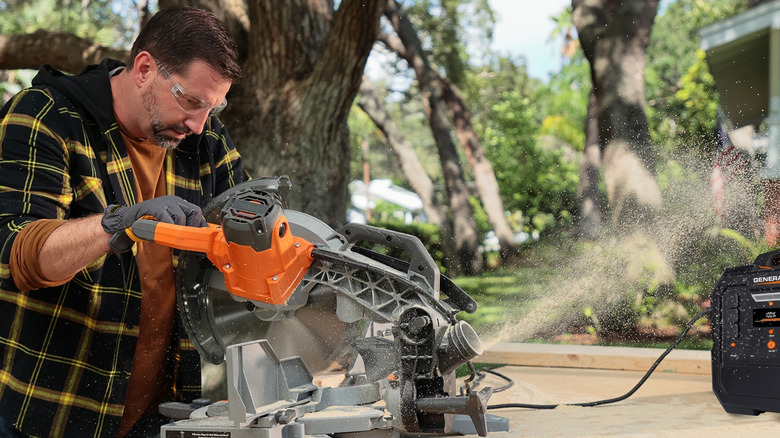 Man using power tool connected to Generac portable generator