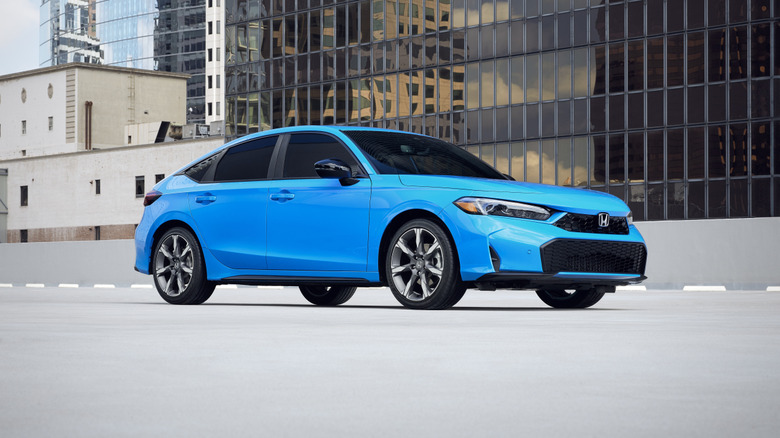 A blue Honda Civic on a parking garage, front 3/4 view
