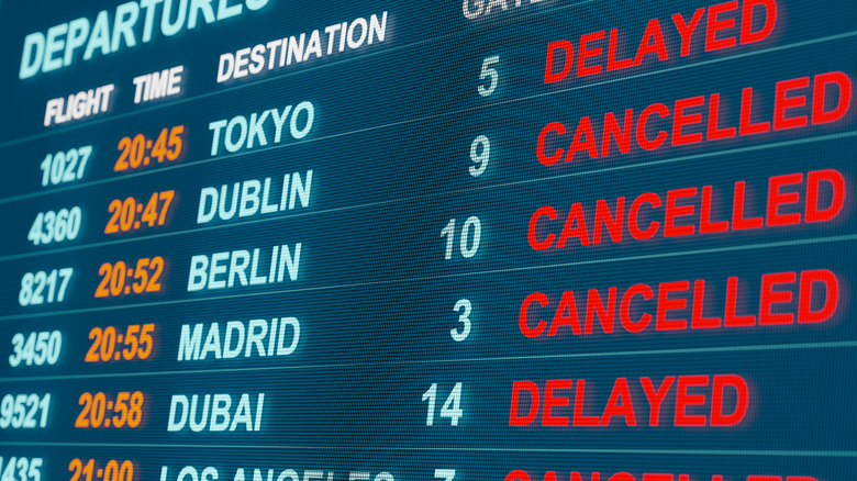 An airport timetable shows a plethora of delayed and cancelled flights.