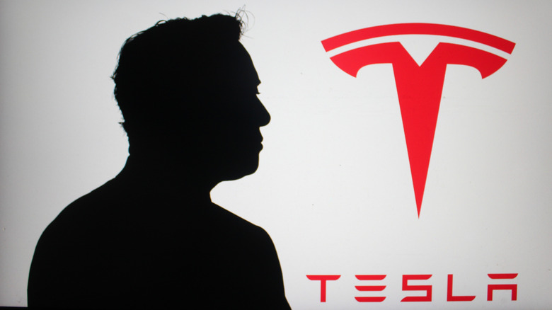 A silhouette of Elon Musk and Tesla logo