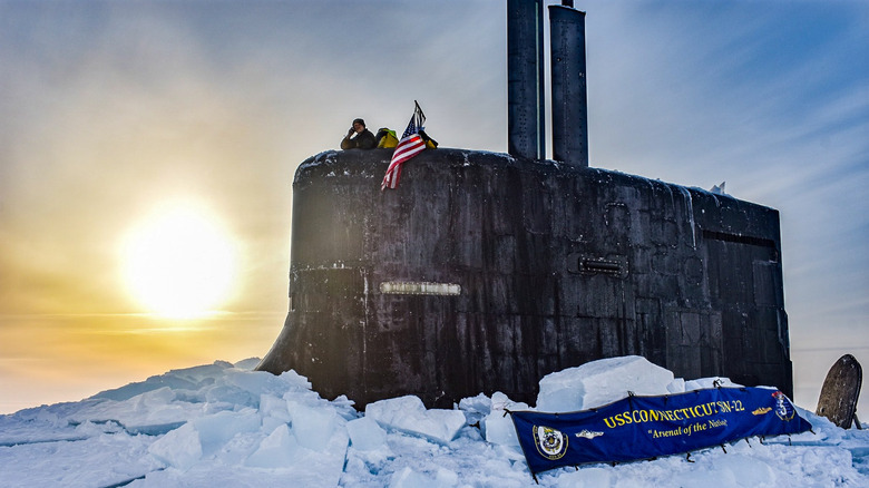 The USS Connecticut poking through the ice with a flag and a banner displayed