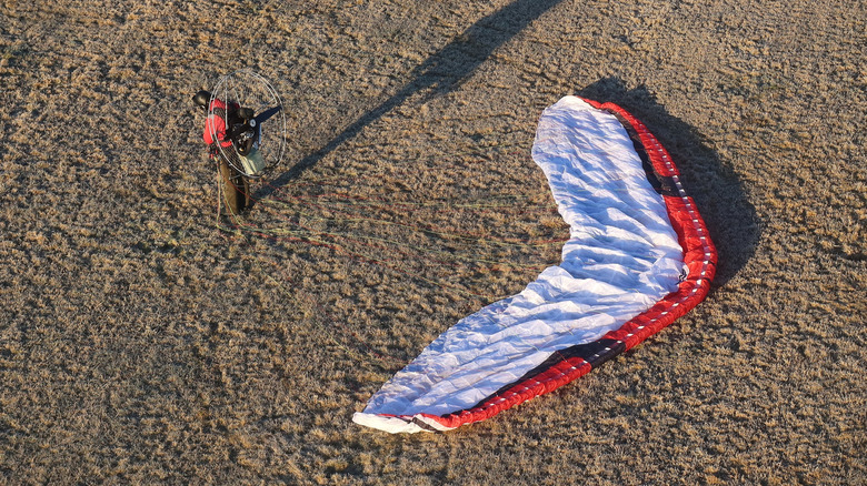 A paramotor pilot getting ready to take-off after unfolding the wing.