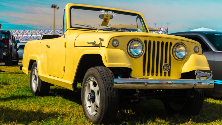Yellow 1968 Jeepster Commando parked on grass