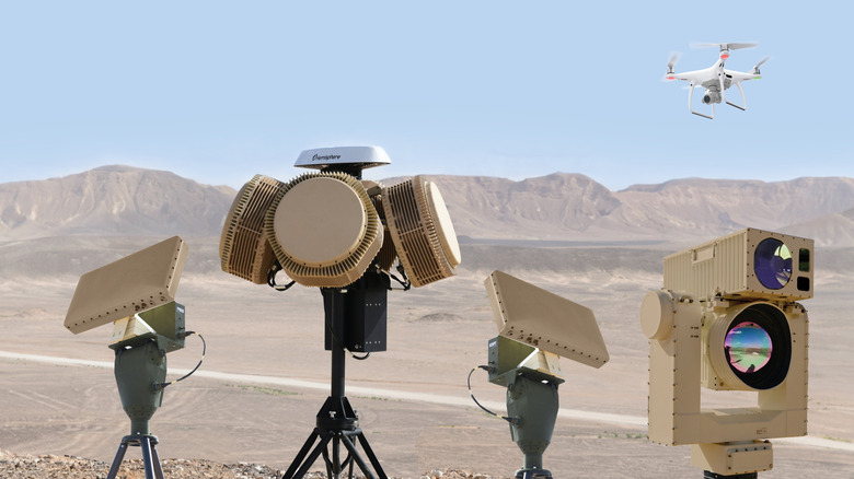 Various radar arrays against desert background with flying drone overhead