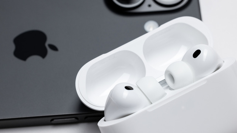An iPhone 17 with an AirPods on top of it
