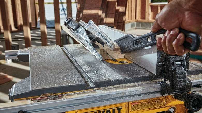A person using a DeWalt table saw at an angle.